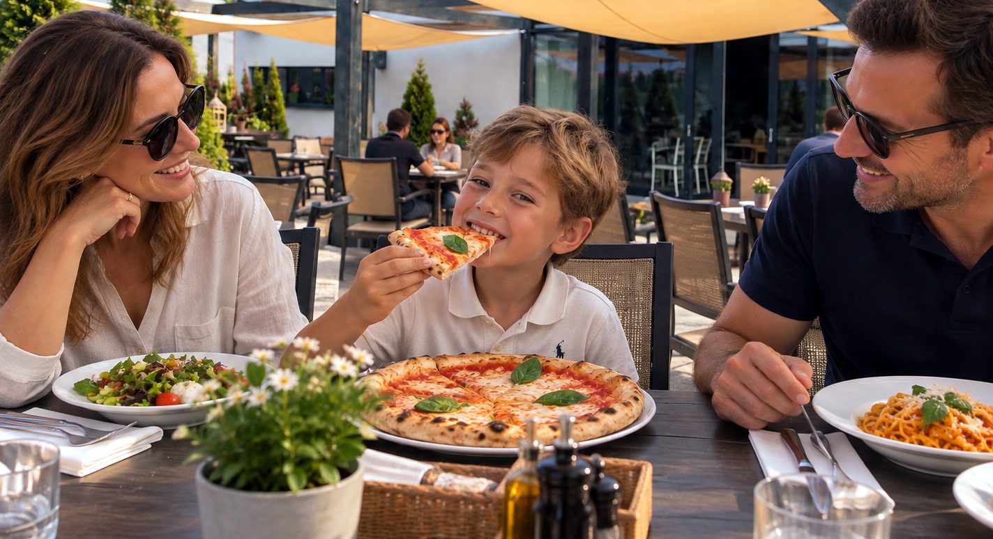 Rodzina z dzieckiem jedzącym pizzę Bambino przy stole na tarasie